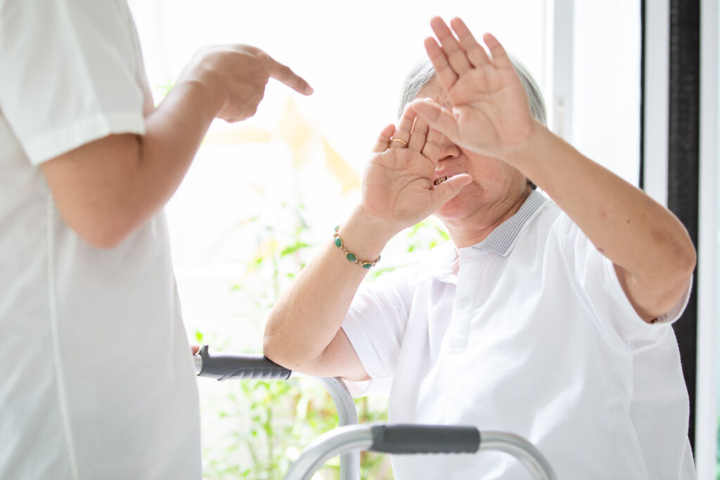 A patient cover her eyes with her hands.